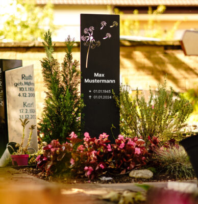 Moderne Aluminium Grabstele mit Pusteblumenmotiv auf bepflanztem Grab